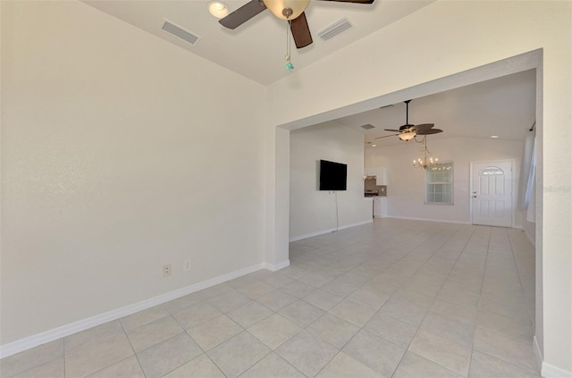 tiled empty room featuring vaulted ceiling and ceiling fan with notable chandelier