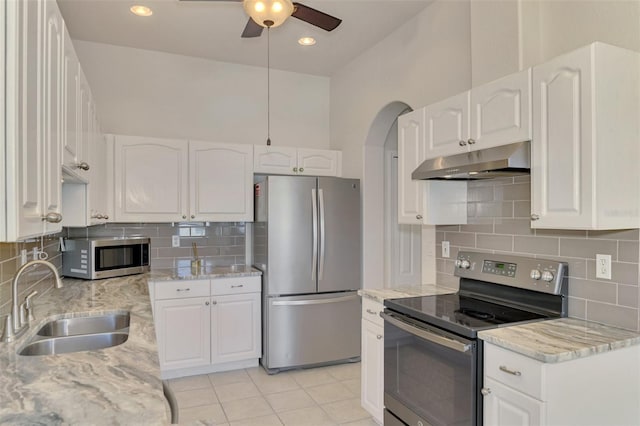 kitchen featuring stainless steel appliances, sink, white cabinets, and light stone counters