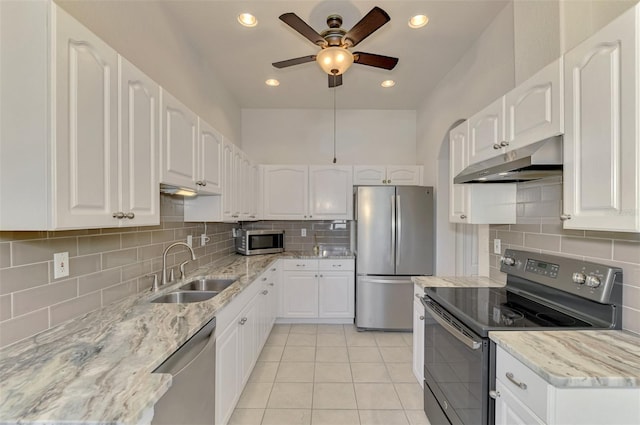 kitchen with light tile patterned floors, appliances with stainless steel finishes, sink, and white cabinets