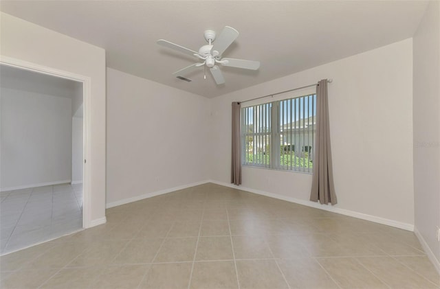 tiled spare room featuring ceiling fan