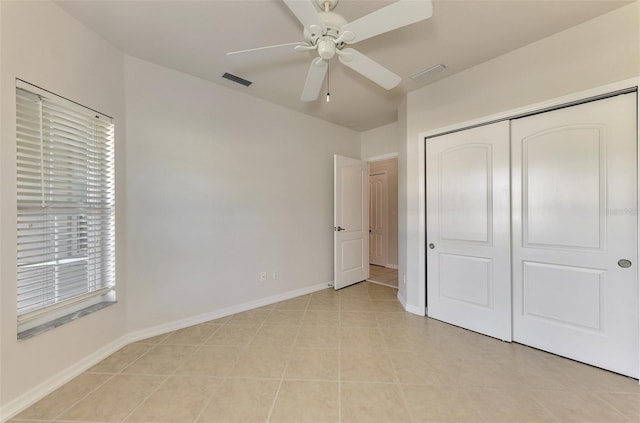 unfurnished bedroom with ceiling fan, a closet, and light tile patterned floors