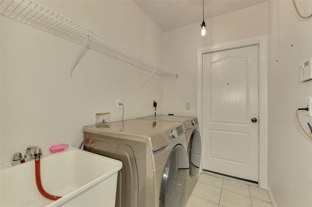 laundry room with sink, light tile patterned floors, and washer and clothes dryer