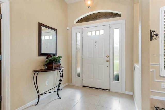 foyer featuring light tile patterned flooring and a wealth of natural light