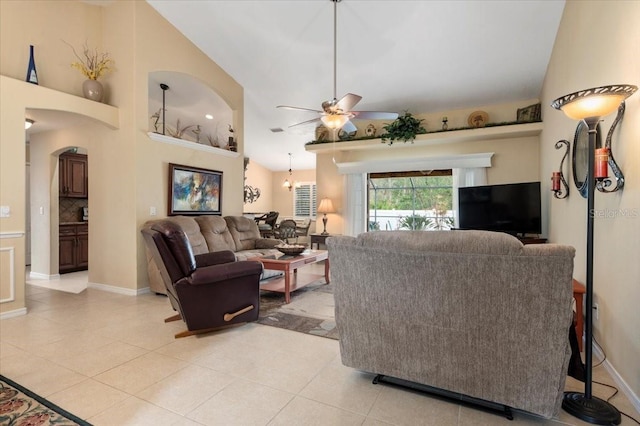 tiled living room featuring ceiling fan with notable chandelier and lofted ceiling