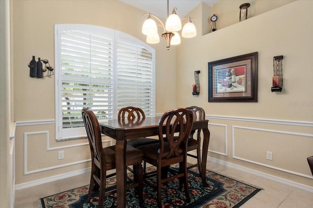 tiled dining room with a chandelier