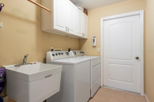 washroom with washing machine and dryer, cabinets, sink, and light tile patterned floors