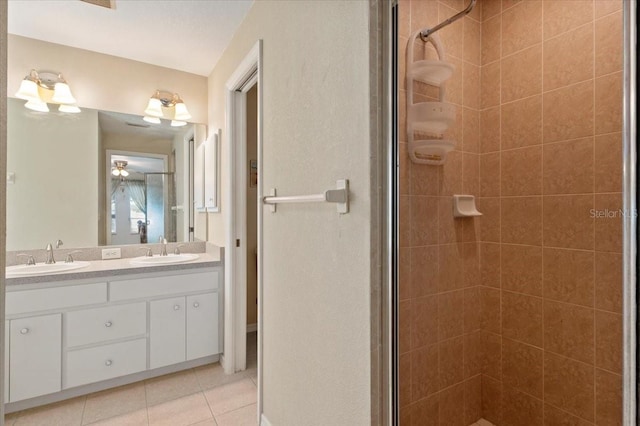 bathroom with tile patterned floors, vanity, and a shower with door