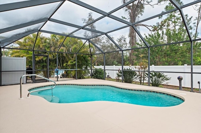 view of pool with a patio and glass enclosure