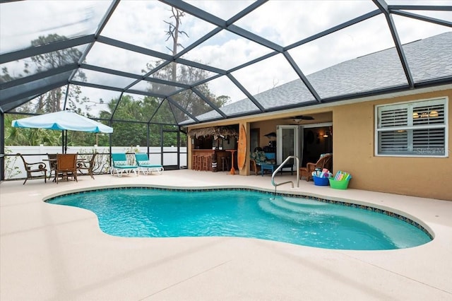 view of pool featuring exterior bar, a lanai, and a patio