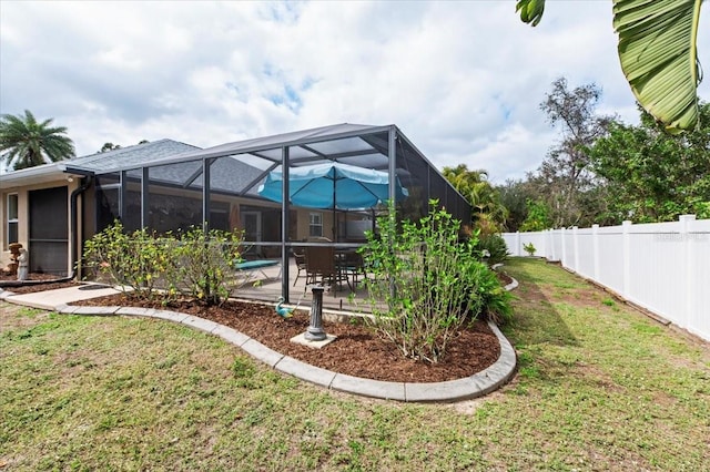 view of yard featuring glass enclosure, a swimming pool, and a patio area