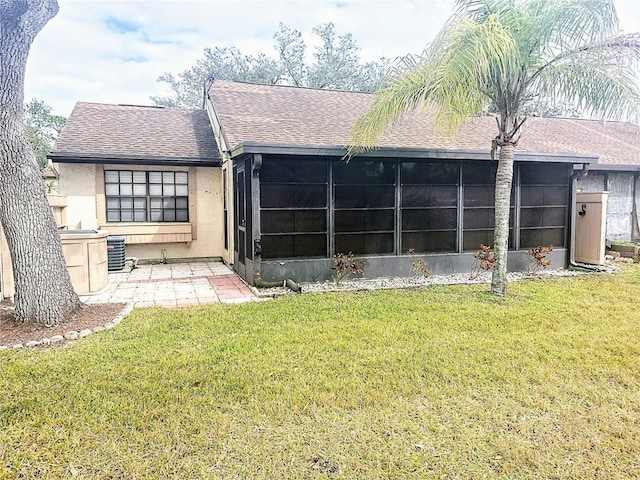 back of house with a sunroom, a patio area, and a lawn