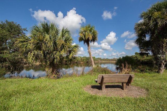 view of property's community with a lawn and a water view