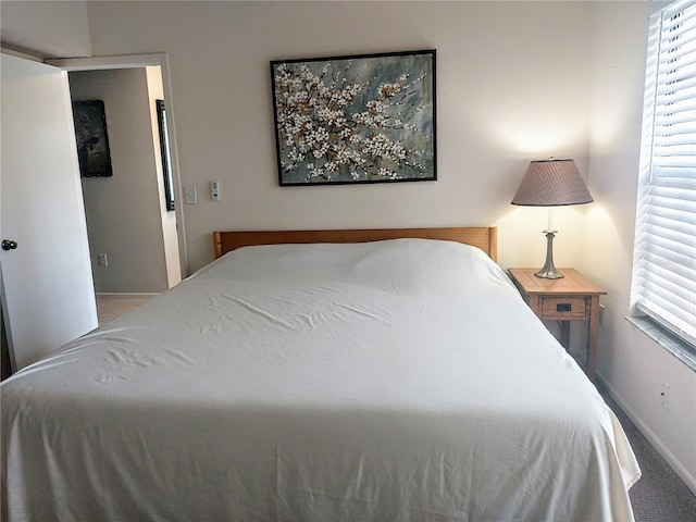 carpeted bedroom featuring multiple windows