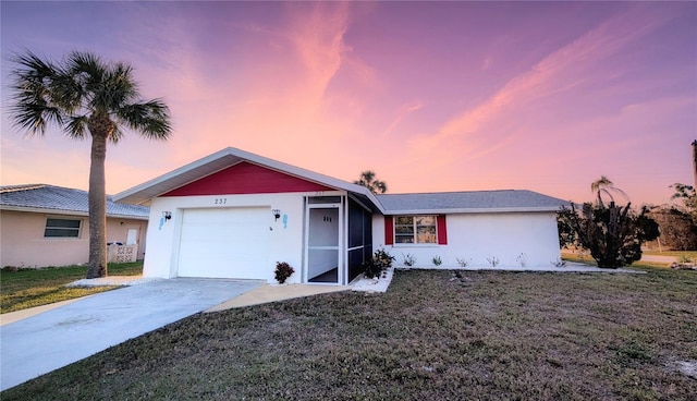 ranch-style home with a garage and a lawn