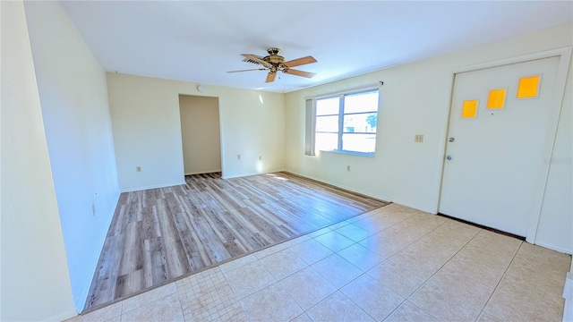 tiled empty room featuring ceiling fan