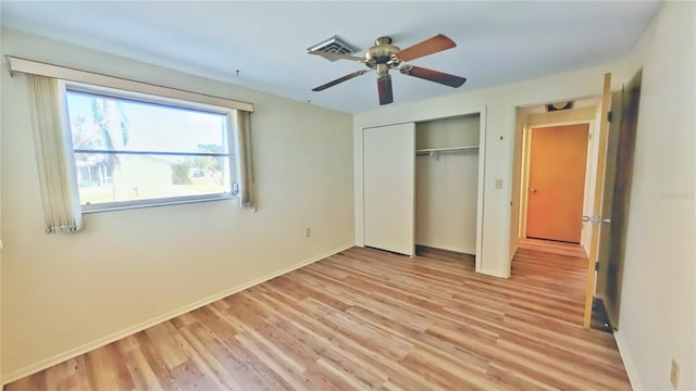 unfurnished bedroom featuring ceiling fan, light wood-type flooring, and a closet