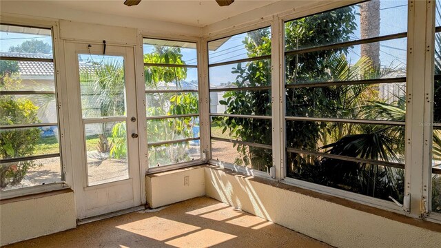 unfurnished sunroom with ceiling fan