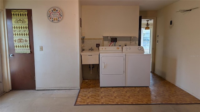 laundry room with sink, washer and dryer, and light parquet flooring