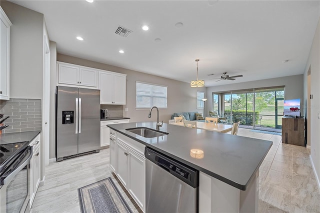 kitchen featuring sink, appliances with stainless steel finishes, plenty of natural light, an island with sink, and white cabinets