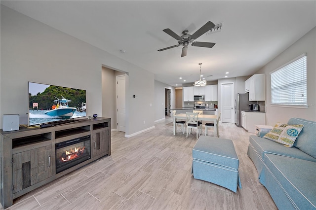 living room with ceiling fan and light hardwood / wood-style floors