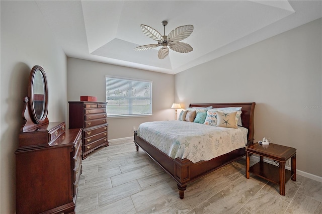 bedroom with a raised ceiling and ceiling fan