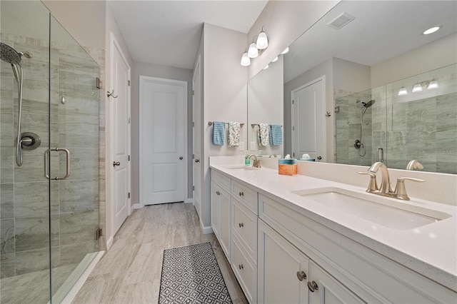 bathroom featuring hardwood / wood-style flooring, vanity, and a shower with door