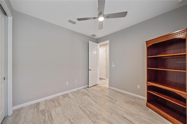 unfurnished bedroom with ceiling fan, a closet, and light hardwood / wood-style flooring