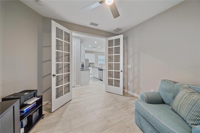 living area featuring sink, ceiling fan, and french doors