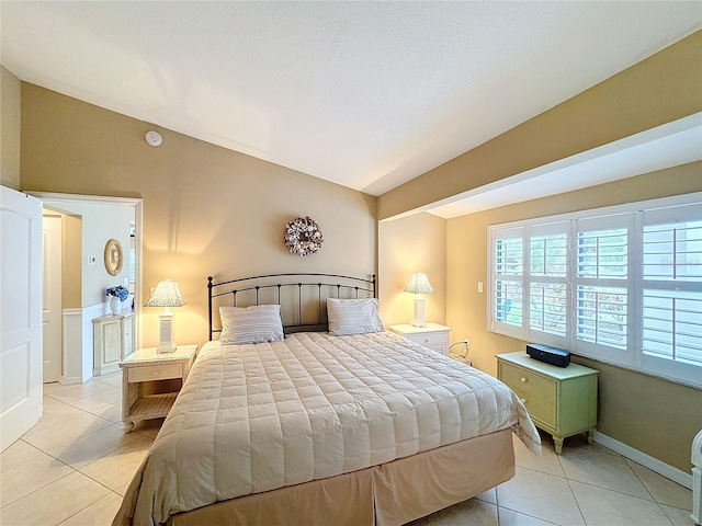 bedroom with vaulted ceiling and light tile patterned floors