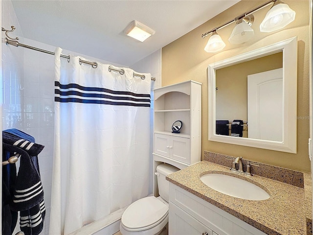 bathroom featuring vanity, walk in shower, and toilet