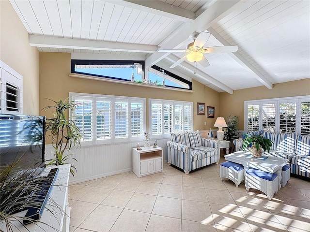 tiled living room with a wealth of natural light, lofted ceiling with beams, and ceiling fan