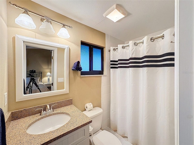 bathroom featuring vanity, a textured ceiling, curtained shower, and toilet