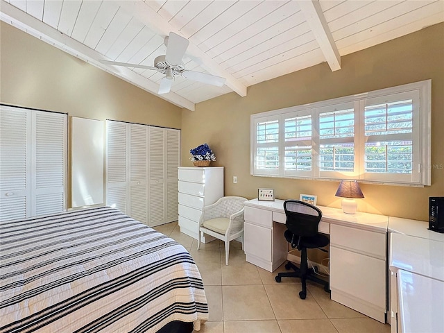 tiled bedroom featuring ceiling fan, multiple closets, lofted ceiling with beams, and wooden ceiling