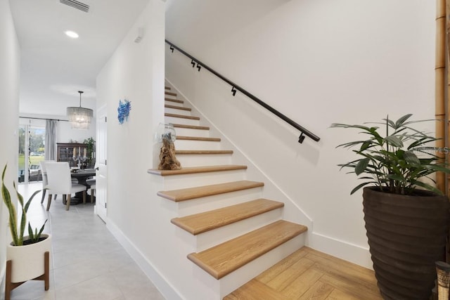 stairs featuring a chandelier