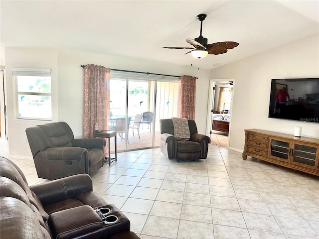 tiled living room featuring ceiling fan, lofted ceiling, and plenty of natural light