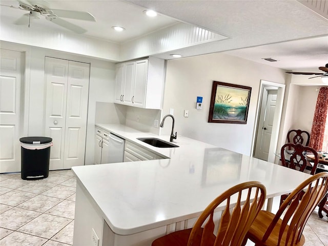 kitchen with kitchen peninsula, sink, white cabinets, ceiling fan, and white dishwasher