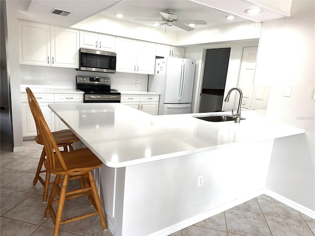 kitchen with appliances with stainless steel finishes, a breakfast bar, sink, and kitchen peninsula