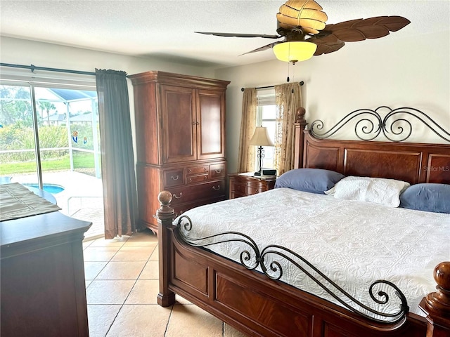 bedroom featuring ceiling fan, light tile patterned floors, access to exterior, and a textured ceiling