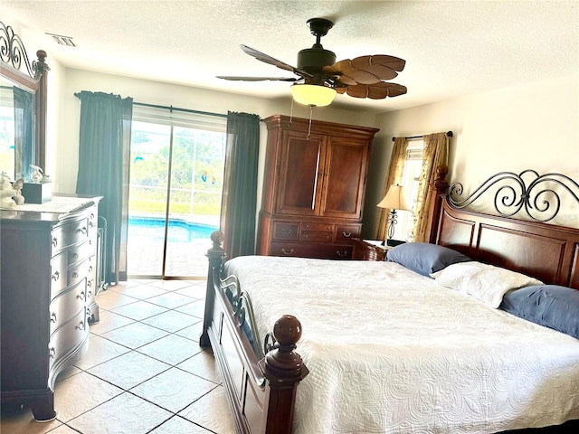 bedroom with ceiling fan, access to exterior, and a textured ceiling