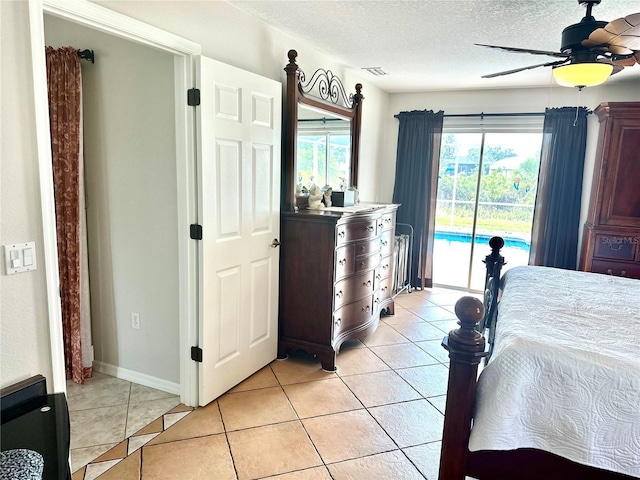 tiled bedroom featuring ceiling fan, access to exterior, and a textured ceiling