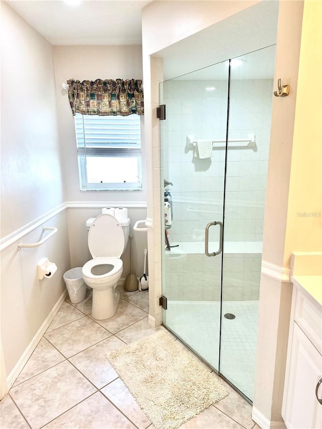 bathroom featuring tile patterned flooring, vanity, an enclosed shower, and toilet