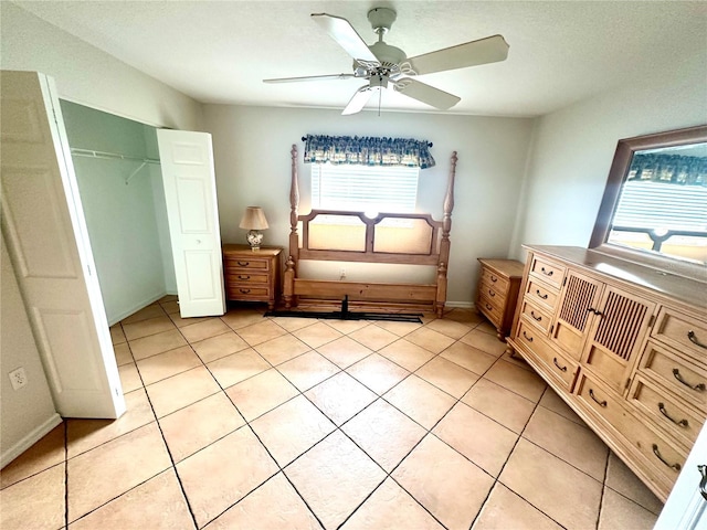 unfurnished bedroom with ceiling fan, a closet, and light tile patterned floors