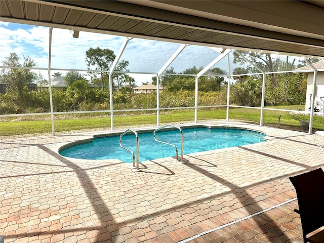 view of swimming pool featuring a patio area, glass enclosure, and a lawn