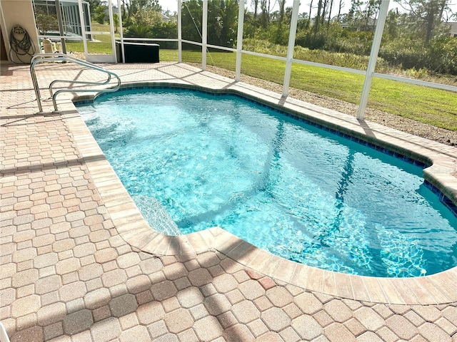 view of swimming pool featuring a lanai and a patio area