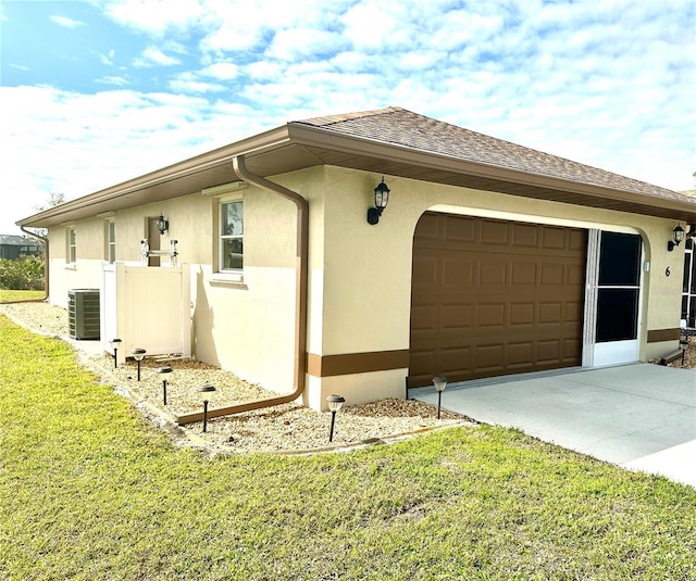 view of property exterior featuring central AC unit, a garage, and a lawn