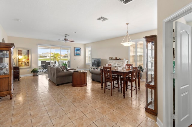 dining room with a ceiling fan, visible vents, baseboards, and light tile patterned floors