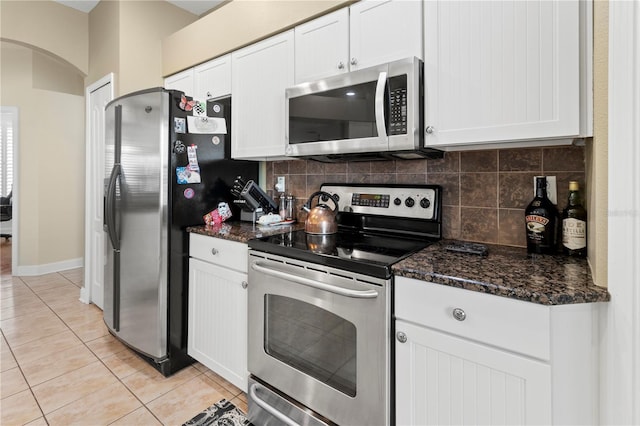 kitchen featuring light tile patterned floors, tasteful backsplash, white cabinetry, and stainless steel appliances