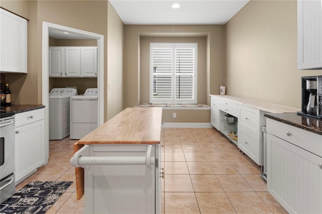 kitchen with independent washer and dryer, wood counters, light tile patterned flooring, and white cabinetry