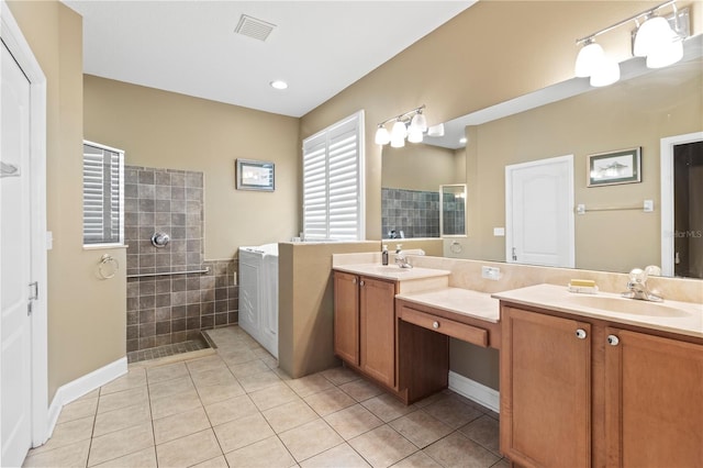 bathroom with double vanity, visible vents, tile patterned flooring, a walk in shower, and a sink