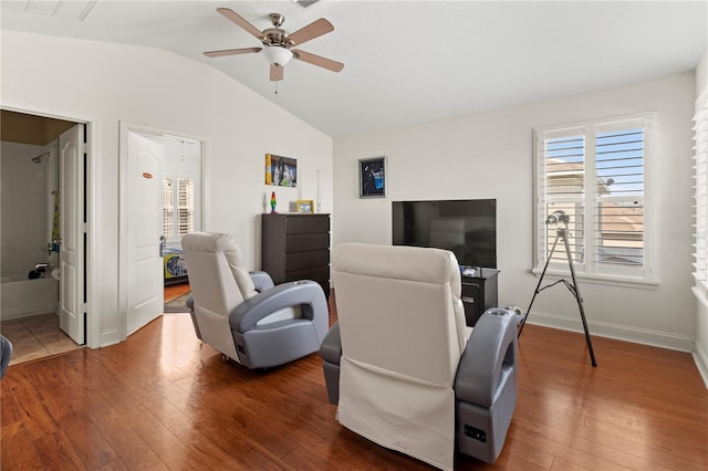 living room featuring hardwood / wood-style flooring, baseboards, vaulted ceiling, and a ceiling fan